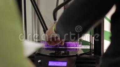男人用他的手<strong>打手</strong>势和一些东西来解释它是如何工作的德尔塔3D打印机。