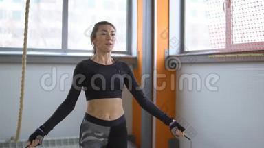 女人在健身房跳绳。 健康生活方式的概念
