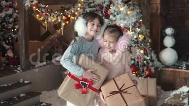圣诞节或新年。 两个小女孩拿着包装精美的礼物的肖像。 儿童收到礼物