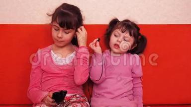 孩子们从手机上听<strong>耳机</strong>上的<strong>音乐</strong>。 两个姐妹用<strong>耳机</strong>听<strong>音乐</strong>。
