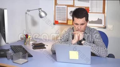 办公室工作人员使用笔记本电脑。 穿着便装的白人男人用笔记本电脑。