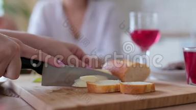 女人把切片黄瓜放在木板上的三明治上