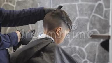 戴着黑色手套的理发师仔细地剃掉一个在理发店里的亚洲孩子的头发，关闭60<strong>英尺</strong>高的头发
