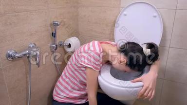 年轻的孕妇疲惫的女人在<strong>坐</strong>在家里地板上的<strong>厕</strong>所里呕吐。