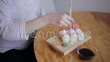 在日本餐馆里用筷子吃寿司的亲密少女