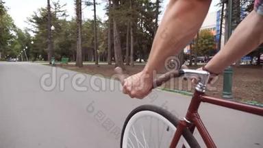 人们在公园路上骑老式自行车的观点。 骑自行车把手的家伙。 健康的生活方式