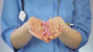 女医生手掌上的粉红色丝带，乳腺癌宣传运动