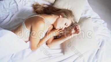 美丽的女孩<strong>睡</strong>在白色的床上，看到早晨的梦