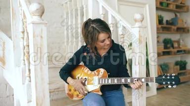 有魅力的年轻女孩学弹电吉他楼梯上学弹电吉他