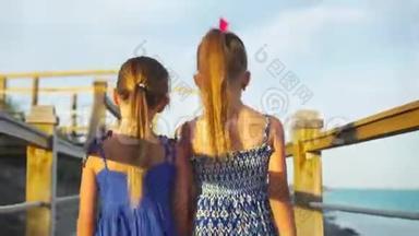 在白色热带海滩的木桥上可爱的小女孩。 亲密的<strong>双手抱</strong>在一起
