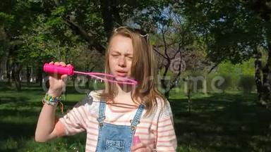 一个十几岁的女孩吹<strong>泡泡</strong>。 阳光明媚的一天公园里的女孩。 一个十几岁的女孩在新鲜空气中玩<strong>泡泡</strong>。