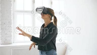 在室内的白色房间里，<strong>VR</strong>耳机里的女人抬起头，试<strong>图</strong>触摸虚拟现实中的物体