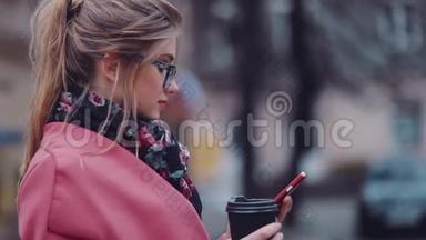 <strong>旋转</strong>观看一个华丽时尚的女孩拿着一杯咖啡，用她的<strong>手机</strong>上网。 商务