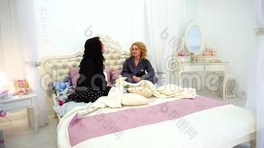两个<strong>女</strong>朋友聊天八卦，<strong>深夜</strong>坐在明亮卧室的床上。