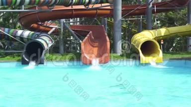 夏季水上乐园的蓝色游泳池里，五颜六色的水管和水滑。 游乐园的室外水上乐园..