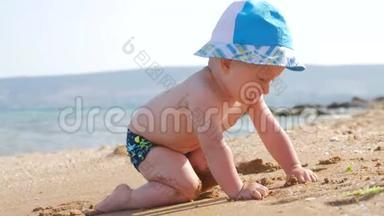 小男孩在海滩上<strong>潮</strong>湿的沙滩上<strong>玩</strong>耍。 他学会爬行，波浪拥抱他。