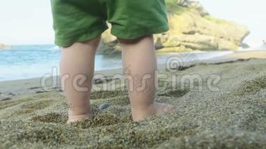 在温暖的阳光下，在诺森西班牙海滩温暖的沙滩上小男孩的脚