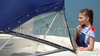 一个黑发女孩在船上摆姿势拍照。 美丽的小女孩模特被拍到