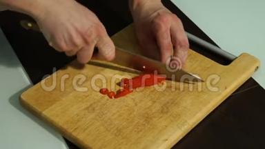 切片红辣椒.. 一个男人在木板上切胡椒