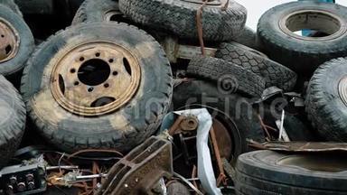 不同车辆的旧生锈车轮白天被倾倒在<strong>废物</strong>处理厂的一堆土地上