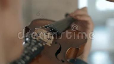 有魅力的有才华的年轻人在感官上拉小提琴。 小提琴手排练特写镜头