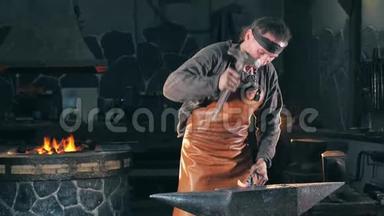 铁匠正用锤子打铁. 慢动作。