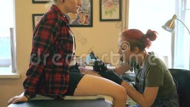 红头发女孩纹身艺术家纹身图片在lef的年轻女孩客户在工作室