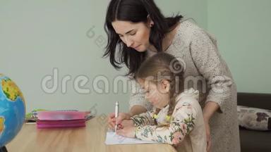 妈妈帮助小女孩在笔记本上正确书写