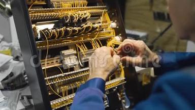 电工将电线<strong>卷起</strong>来，在仪表盘的一个电路中，用高压工作