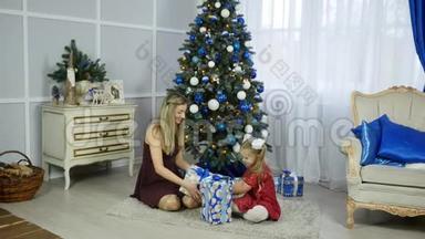 圣诞早晨，<strong>一家人</strong>的母亲和孩子的<strong>女儿</strong>在圣诞树上带着礼物