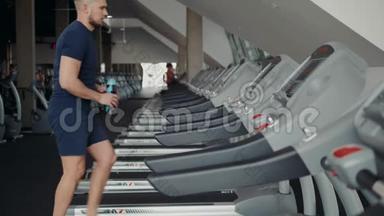 运动服的年轻人在健身房跑步机上跑步，开始准备训练锻炼