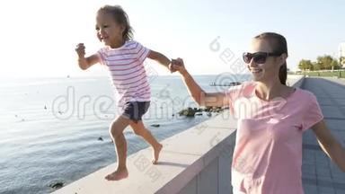 年轻的母亲和小女儿牵着手跑着，笑着笑着
