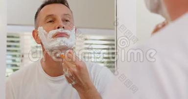 男人在浴室用剃须刀刮胡子