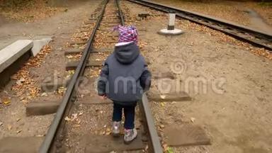 一个小<strong>女孩</strong>走在铁轨上。 秋天