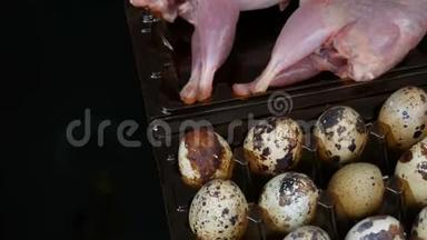 鹌鹑的新鲜肉在黑色背景的鹌鹑蛋旁边的塑料棕色托盘中旋转