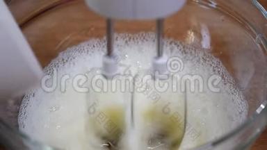加糖的同时拌甜奶油.. 用电动搅拌<strong>器</strong>在碗中混合白<strong>蛋</strong>霜。