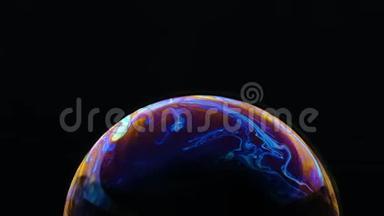 一个肥皂泡的五彩彩虹颜色看起来像一个在<strong>黑色</strong>背景下孤立的梦幻<strong>星球</strong>