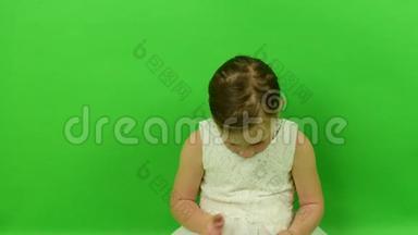 可爱的小女孩在色度键背景上阅读电子书。 穿着浪漫裙子的小女孩。 白色<strong>婚纱礼服</strong>