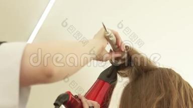 理发师在理发后用刷子和烘干机给长发发型。 把<strong>剪发</strong>器合上，用