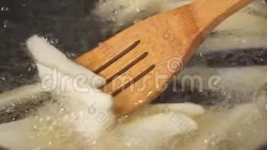 土豆片用油煎锅煎，用木铲搅拌土豆，慢动作