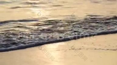 在日落的桑迪海滩上，海面掀起了一阵平静的巨浪。 海水中的太阳反射。 自然背景。 晚上