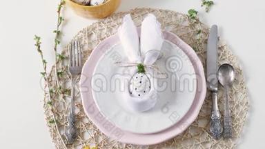 美丽的节日复活节餐桌设置与餐巾复活节兔子。 节日的复活节餐桌设置。 复活节餐桌