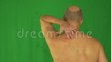 男人用左手揉着脖子和肩膀。 最接近后景。 锁定目标。