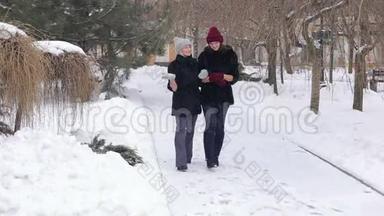 <strong>冬天</strong>，两个穿着黑色毛皮<strong>大衣</strong>的漂亮女孩在公园里散步。