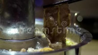 传统北京火锅的慢动作与甜甜圈形状的黄铜锅。