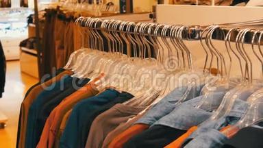 时尚的青年服装挂在购物中心的服装店的衣架上。