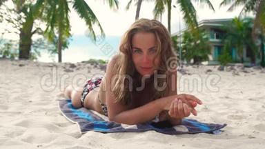 描绘年轻女子暑假在沙滩上<strong>晒太阳</strong>。 美丽的<strong>女人</strong>在海边晒黑。