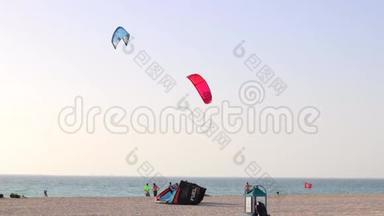 两个风筝板在海滩上跳跃