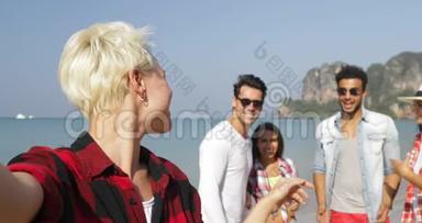 女孩欢迎人们团体在沙滩上自助拍照手机快乐度假游客