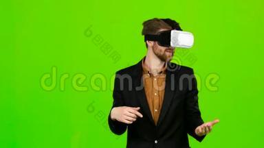 虚拟现实中的商人正在享受乐趣和微笑。 绿色屏幕
